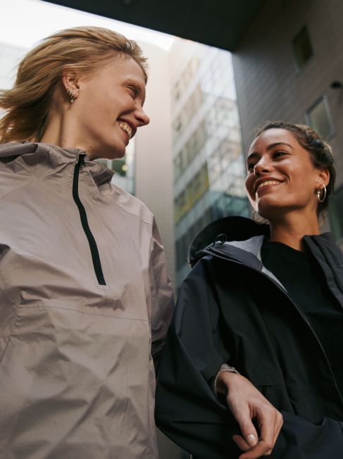 Two women smiling as they walk through the city