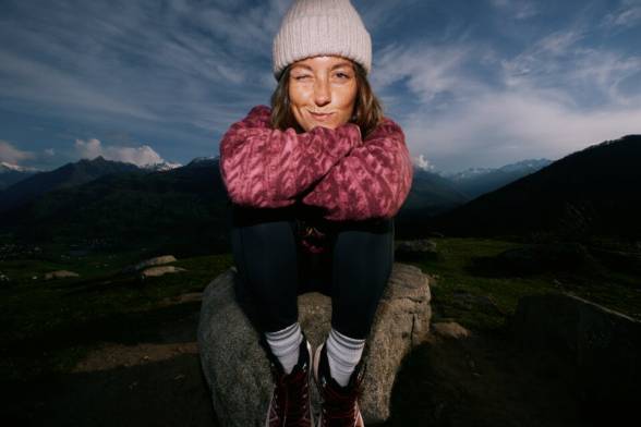 Close-up of a person in hiking boots scrambling over a rock