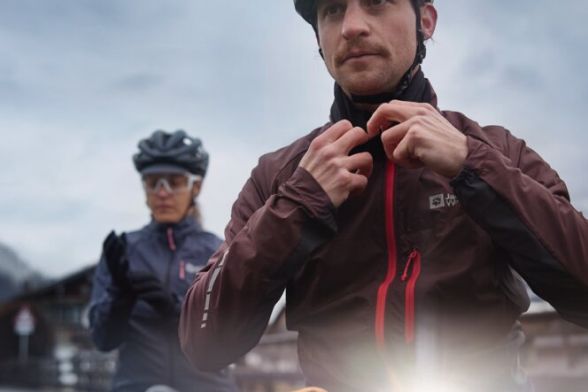 Frontal close-up of two cyclists in foggy mountain landscape